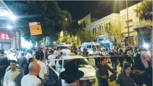  ?? (News24) ?? SECURITY OFFICIALS and passersby gather at the site of a stabbing attack outside the Jerusalem Central Bus Station last night.