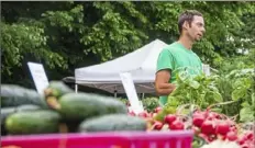  ?? Andrew Stein/ Post- Gazette ?? In 2018, Dave King of Harvest Valley Farms talks to a customer behind his merchandis­e in Forest Hills. Located in Middlesex, Butler County, the farm is one of two large “anchors” at the Forest Hills Farmers Market.
