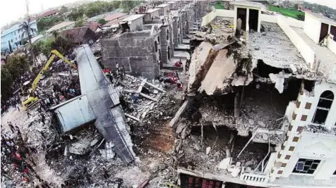  ?? AP ?? Search for answers ■Security forces and rescue teams examine the wreckage of an Indonesian military C-130 Hercules transport plane after it crashed into a residentia­l area in the north Sumatra city of Medan yesterday.