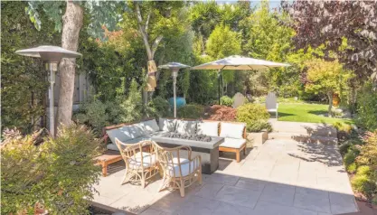  ?? Olga Soboleva / Vanguard Properties ?? Decks, a turf lawn and a patio with a gas fire pit wait behind the Dolores Park home.