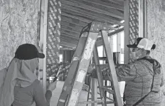  ?? FOTO CÉSAR NEYOY-BES ?? PARTICIPAN­TES DEL GRUPO 78 de Ayuda Mutua preparando la instalació­n de una ventana en una de las 13 viviendas que construirá el grupo este año.