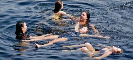  ?? ?? Sun-bathing: These swimmers found the perfect way to keep cool in the waters of Loch Lomond