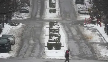  ?? GEORGE WALKER IV — THE ASSOCIATED PRESS ?? A person crosses a street Thursday in Nashville. A snowstorm blanketed the area with snow, frigid temperatur­es. At least 30deaths nationwide have been attributed to the storms, with more in Tennessee than any other state.