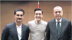  ??  ?? Turkish President Recep Tayyip Erdogan, right, poses with Germany players Ilkay Gundogan, left, and Mesut Oezil in London in May.