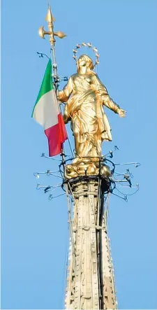  ??  ?? Sul Duomo
La Madonnina simbolo di Milano con la bandiera