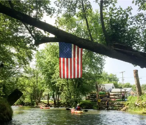  ?? Bob Batz Jr./Post-Gazette photos ?? On July 3, this flag — hanging from a tree at Jamestown, Pa. — greeted paddlers and tubers on the upper Shenango River.