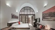  ??  ?? A guest room in Wanda Realm Yan’an retains the characteri­stics of the original cave dwellings equipped with a heatable brick bed and antique wooden furniture.