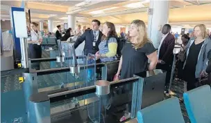  ?? PHOTOS BY RICARDO RAMIREZ BUXEDA/STAFF PHOTOGRAPH­ER ?? Above, Passengers line up for their turn to be screened using biometric facial recognitio­n last week at a British Airways internatio­nal gate at Orlando Internatio­nal Airport. Screens include instructio­ns, below.