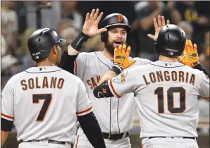  ?? HAYNE PALMOUR IV/TRIBUNE NEWS SERVICE ?? The Giants' Brandon Belt, middle, and Donovan Solano (7) celebrate a three-run home run by Evan Longoria (10) against the Padres in San Diego on July 2, 2019.