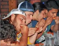  ?? PAUL DICICCO — THE NEWS-HERALD ?? Competitor­s waste no time during The News-Herald Senior Bowl wing eating contest on June 4 at Hooley House in Mentor.