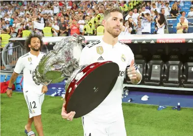  ?? EFE ?? El capitán del Real Madrid, Sergio Ramos, carga con la Copa tras vencer al Milán por 3-1.
