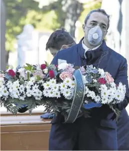  ?? REUTERS / FLAVIO LO SCALZO ?? Un trabajador del cementerio de Bérgamo porta una máscara.