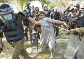  ?? AP photo ?? Police detain a supporter of Pakistan’s former Prime Minister Imran Khan who with others are protesting against the arrest of their leader, in Lahore, Pakistan on Wednesday. Khan can be held for eight days, a court ruled Wednesday, a day after the popular opposition leader was dragged from a courtroom and arrested on corruption charges, deepening the country’s political turmoil.