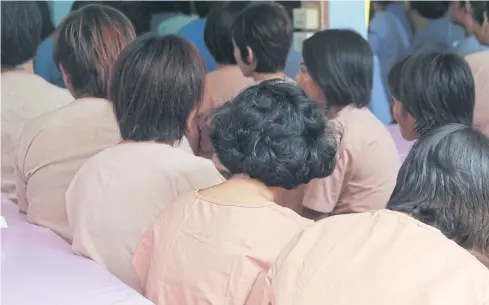  ?? APICHIT JINAKUL ?? Female inmates wait for lunch inside a prison in Pathum Thani. Thailand’s prisons are among the world’s most crowded.