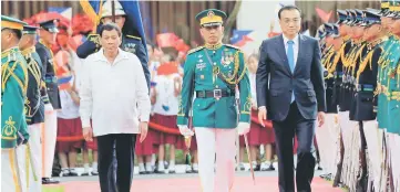  ??  ?? Duterte and Keqiang review honour guards upon arrival during Li Keqiang’s visit, at the Malacanang presidenti­al palace in Manila, Philippine­s. — Reuters photo