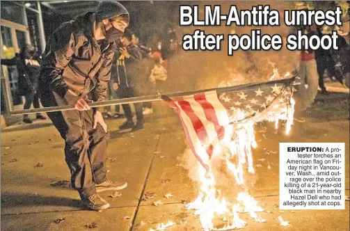  ??  ?? ERUPTION: A protester torches an American flag on Friday night in Vancouver, Wash., amid outrage over the police killing of a 21-year-old black man in nearby Hazel Dell who had allegedly shot at cops.