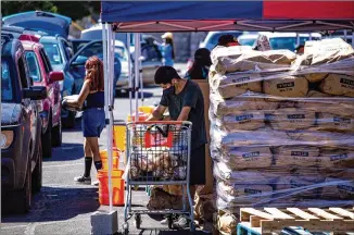  ?? JOEL ANGEL JUAREZ / BLOOMBERG ?? The pandemic has caused an increase in how many people need assistance to feed their families, and they often wait hours in food bank lines such as this one in El Paso, Texas.