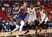  ?? Lynne Sladky / Associated Press ?? Denver center Nikola Jokic drives to the basket as Miami center Orlando Robinson tries to defend.