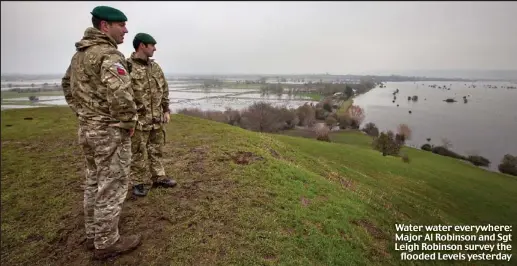  ??  ?? Water water everywhere: Major Al Robinson and Sgt Leigh Robinson survey the
flooded Levels yesterday