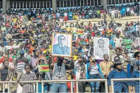  ?? /AFP ?? ‘A giant tree’: Mourners hold portraits of Zimbabwe’s late president Robert Mugabe at a farewell ceremony on September 14 at the National Sports Stadium in Harare. Mugabe died in Singapore on September 6 after a long battle with prostate cancer.