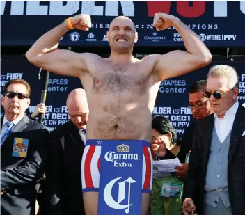  ??  ?? British boxer Tyson Fury flexes during a weigh-in ceremony Friday in Los Angeles.