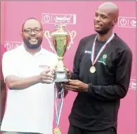  ?? (Courtesy pic) ?? Correction­al Services Captain, Fortune Nerves receives the trophy from SBS Manager Marketing Veli Dlamini (L) after SBS Netball Championsh­ips.