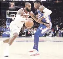  ?? AP ?? LeBron James, de los Cavaliers, maneja el balón ante la defensa de Robert Covington, de los Sixers, durante el desafío de ayer en el baloncesto de la NBA.