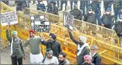  ??  ?? Security personnel stand guard as farmers protest against the new farm laws at Singhu border on Saturday.