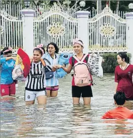  ?? THANIS SUDTO / AP ?? Un grupo de mujeres camina por una calle inundada en Koh Phangan