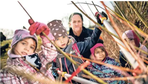  ?? RP-FOTO: RALPH MATZERATH ?? Weidenschn­itt mit Schulen und Kindergärt­en am Haus Bürgel in der Kämpe: Antonia, Nele, Norbert Tenten, Ronja und Luisa (v. l.).