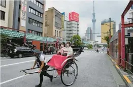  ?? HIRO KOMAE/AP ?? A man transports customers in a rickshaw last week in Tokyo’s Asakusa district. Japan is bracing for a return of tourists as COVID-19 restrictio­ns are loosened.
