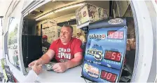  ?? AP ?? Chris Raff of Lincoln, Nebraska, hands a Powerball ticket to a customer in Omaha, Nebraska, on Saturday. The Powerball lottery jackpot had grown to an estimated $435 million after more than two months without a winner.