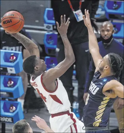 ?? Darron Cummings The Associated Press ?? Arkansas guard Davonte Davis shoots over Oral Roberts forward Kevin Obanor in the first half of a comeback victory in the South Region semifinals at Bankers Life Fieldhouse.