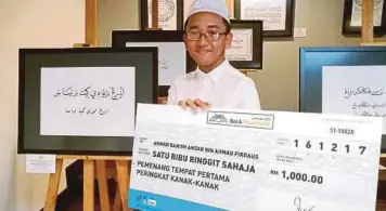  ??  ?? AHMAD Danish Amzar menunjukka­n hadiah tempat pertama peringkat kanak-kanak Pertanding­an MPSK 2017 di Muzium Kesenian Islam Malaysia, semalam.