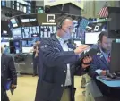  ??  ?? Traders work on the floor of the New York Stock Exchange. On Tuesday, it rose 1,167 points, or 4.9%, to close at 25,018.16.