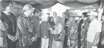  ??  ?? Fatimah (fourth left), flanked by Rosey and Dennis, greets the recipients at the presentati­on of assistance at Dynasty Hotel Miri. On Dennis’ right is Pui.