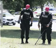  ?? VERONICA HENRI / POSTMEDIA NEWS ?? Police investigat­e at the scene of a double killing in a suburban Toronto-area neighbourh­ood on Friday.