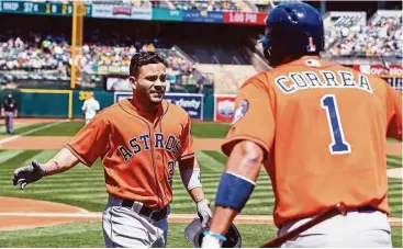  ?? Jason O. Watson / Getty Images ?? José Altuve (izq.) es saludado por Carlos Correa luego de pegar un jonrón ante los Atléticos en Oakland.