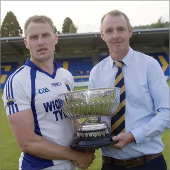  ??  ?? County Chairman Martin Fitzgerald presents the Dunne Cup to St Patrick’s captain Dean Healy.