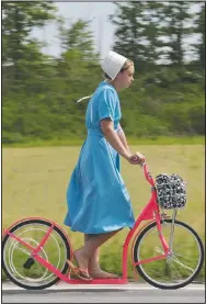  ?? (File Photo/AP/Tony Dejak) ?? An Amish girl rides her scooter.