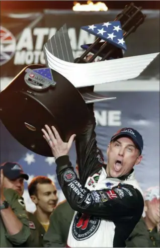  ?? JOHN BAZEMORE - THE ASSOCIATED PRESS ?? Kevin Harvick hoists the trophy after winning the NASCAR Cup Series auto race at Atlanta Motor Speedway in Hampton, Ga., last Sunday.