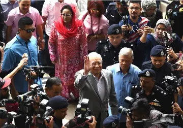  ??  ?? Najib waves to the crowd upon arrival at Kuala Lumpur High Court. Behind him is Rosmah— Bernama photo