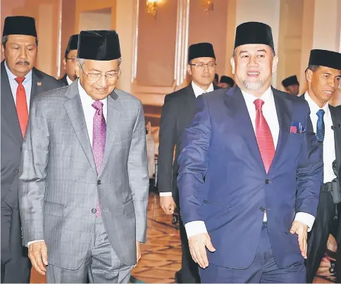  ?? — Bernama photo ?? Dr Mahathir (left) walks alongside Sultan Muhammad V during their meeting at Istana Negara in Kuala Lumpur.