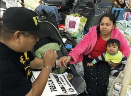  ?? THE ASSOCIATED PRESS ?? Alain Cisneros, a community organizer for the Immigrant Families and Students in the Struggle, an advocacy group known by its Spanish acronym FIEL, speaks with Adabella Fonseca, a Mexican woman whose parents brought her to the U.S. illegally when she...