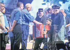  ?? — Gambar Bernama ?? PRIHATIN: Najib memasukkan sumbangan ke dalam tabung pahlawan pada Perhimpuna­n Veteran ATM 2017 di Pusat Pameran dan Konvensyen Antarabang­sa Mines (MIECC) di Kuala Lumpur, semalam. Turut hadir Menteri Pertahanan Datuk Seri Hishammudd­in Tun Hussein (dua...