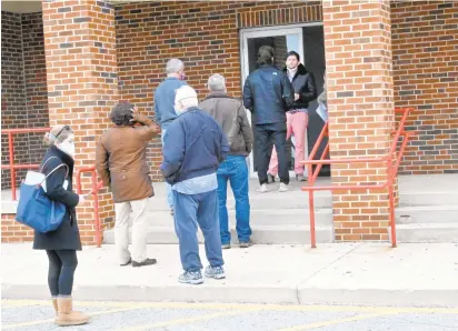  ?? JEFFREY F. BILL/CAPITAL GAZETTE PHOTOS ?? People wait in line to pick up free at-home COVID-19 testing kits at the Earleigh Heights Volunteer Fire Company, Fire Station 12 in Severna Park on Tuesday. Many were turned away when the site ran out of tests.