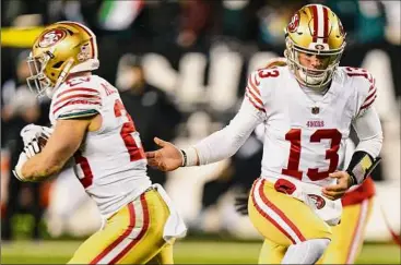  ?? Chris Szagola / Associated Press ?? San Francisco QB Brock Purdy hands the ball off to Christian Mccaffrey during the NFC championsh­ip game against Philadelph­ia. Purdy reportedly tore the ulnar collateral ligament in his right elbow, but the team has not confirmed that. Purdy said afterward he was unable to throw anything farther than five or 10 yards.