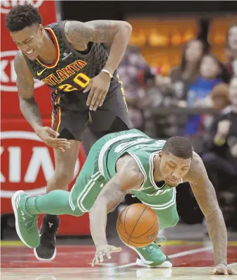  ?? AP PHOTO ?? FOUR ON THE FLOOR: Celtics guard Marcus Smart, right, goes to the floor for the ball as he collides with Atlanta’s John Collins in the second quarter last night.