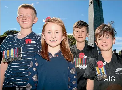  ?? KAVINDA HERATH/ STUFF ?? Jack Ramsay, 8, Madison Ramsay, 6, Samuel Ramsay, 8, and George Ramsay, 5, proudly show medals at an Armistice Day Remembranc­e service at the Invercargi­ll Cenotaph yesterday.