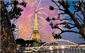  ?? DOMINIC ARIZONA BONUCCELLI/RICK STEVES’ EUROPE ?? On Bastille Day, some 500,000 revelers spend the day picnicking at the base of the Eiffel Tower. The celebratio­n culminates with a fireworks show at the tower, where France’s national anthem rings through the Champ de Mars.